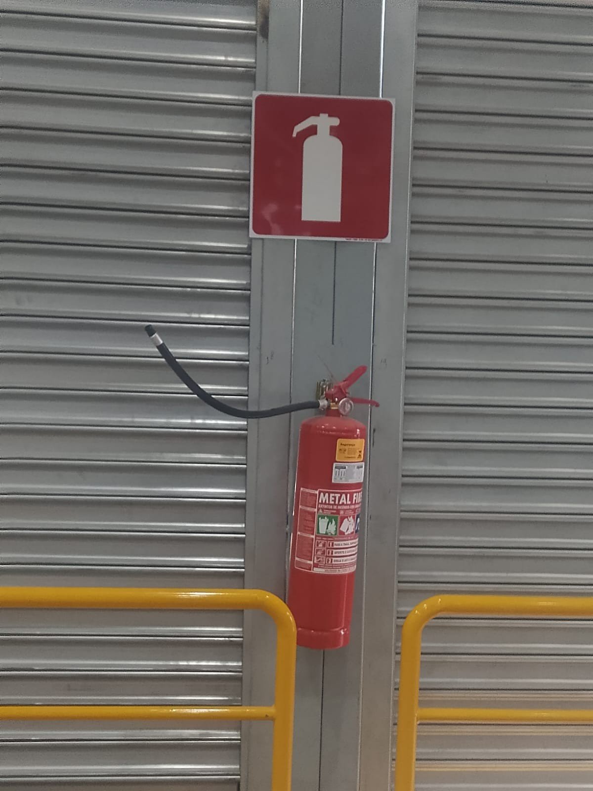 Extintor sinalizado junto ao portão da doca